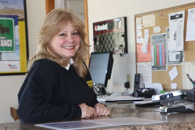 woman standing at the front desk of a car care center