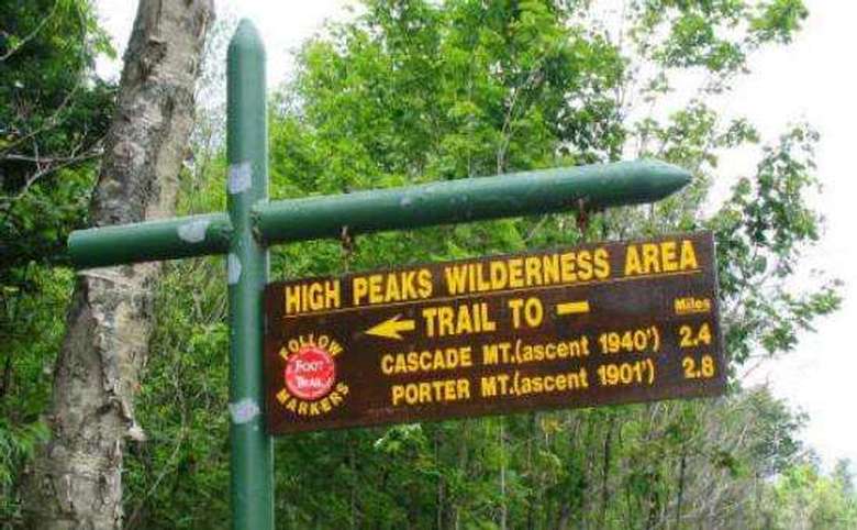 sign that says high peaks wilderness area trail to cascade and porter mountains