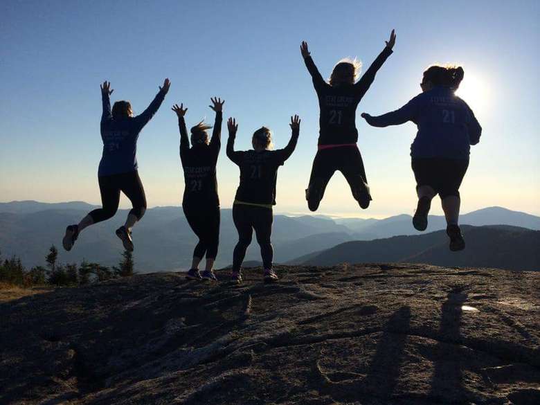 five women jumping at the top of cascade mountain