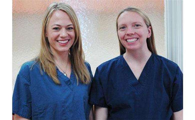two women in scrubs smiling