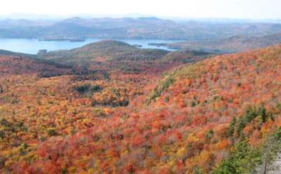 view of fall foliage from the sleeping beauty mountain summit and lake george in the distance