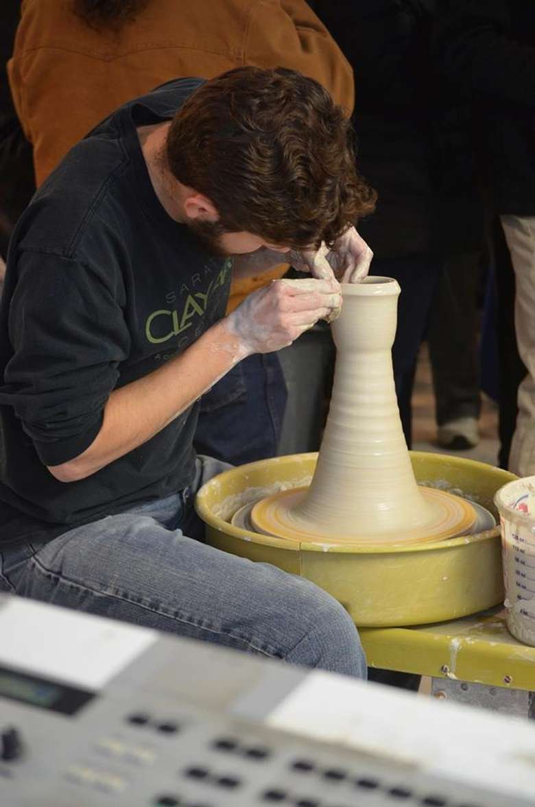 artist sculpting clay on a wheel