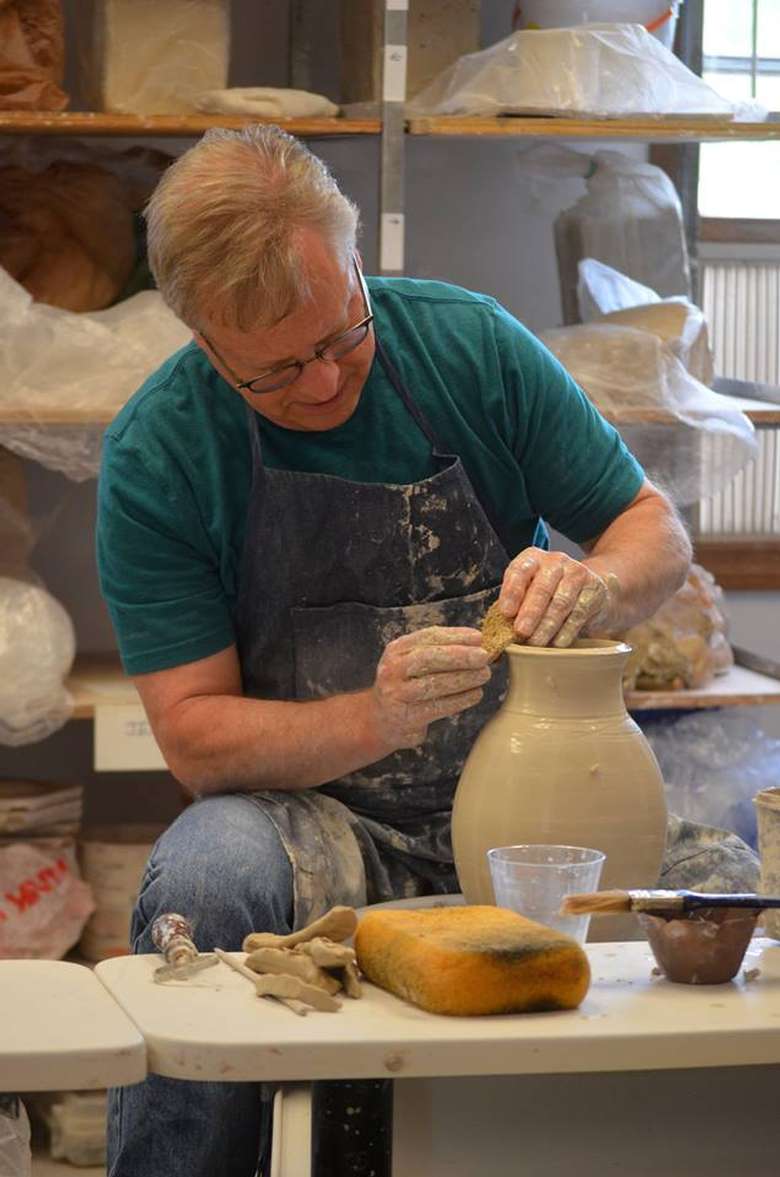 artist sculpting clay on a wheel