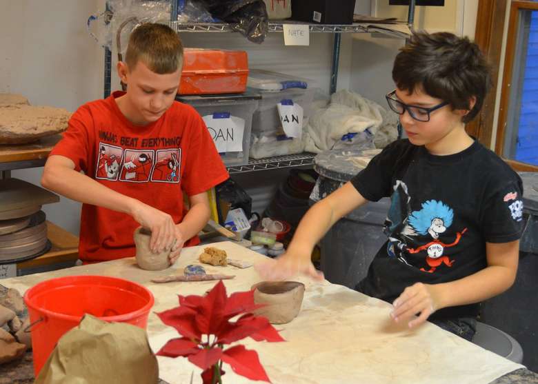 two boys working with clay