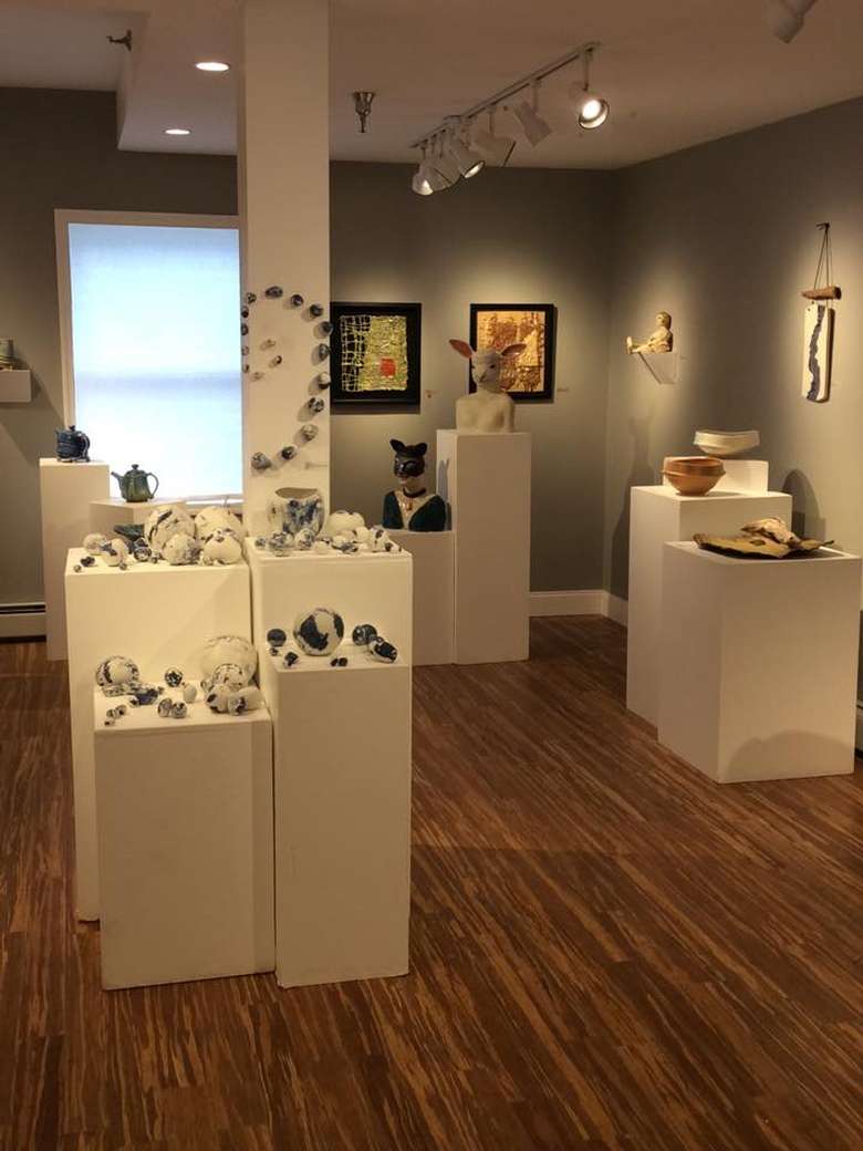 gallery with clay art and paintings on the walls