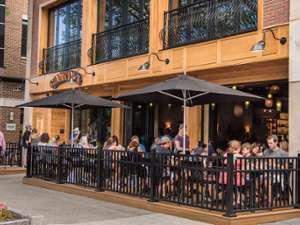 people seated at patio outside restaurant in a city