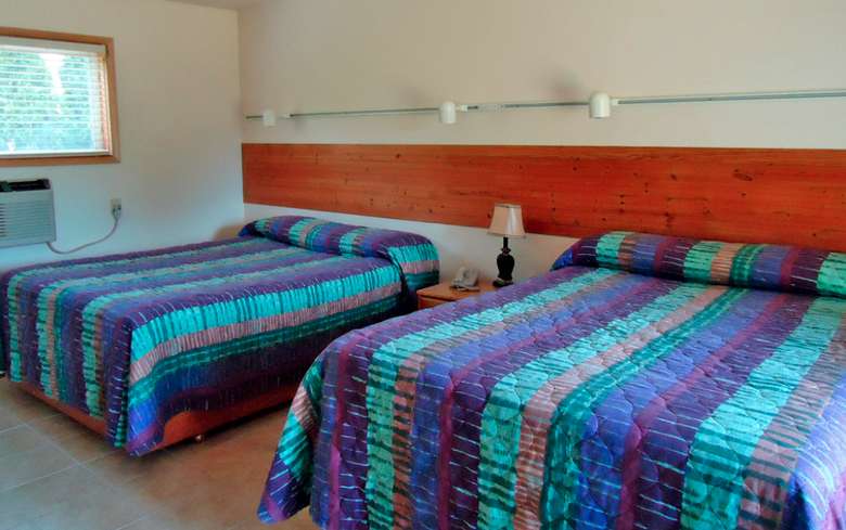 two beds with striped comforters in a motel room