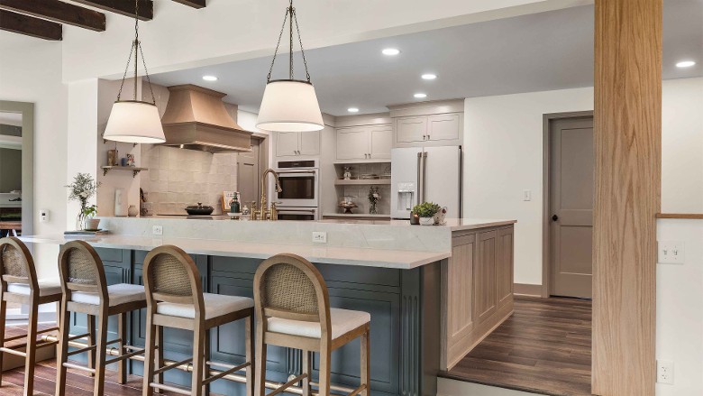 a modern kitchen with a large breakfast bar with four chairs