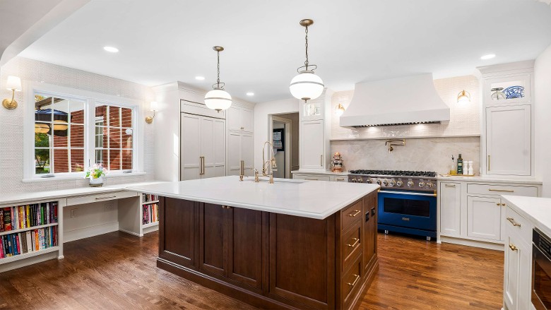 a spacious modern kitchen with two lights above the island