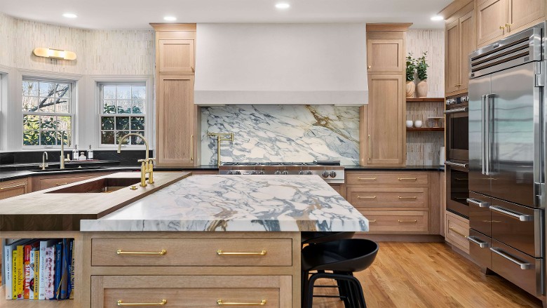a kitchen space with an island that has a granite countertop and sink