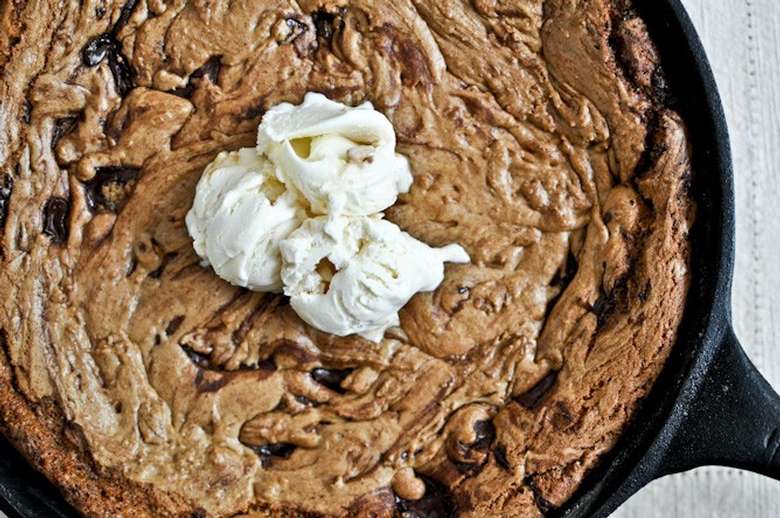 large cookie or brownie in a skillet topped with whipped cream