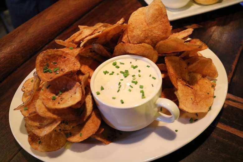 cup of dip with chips on a plate