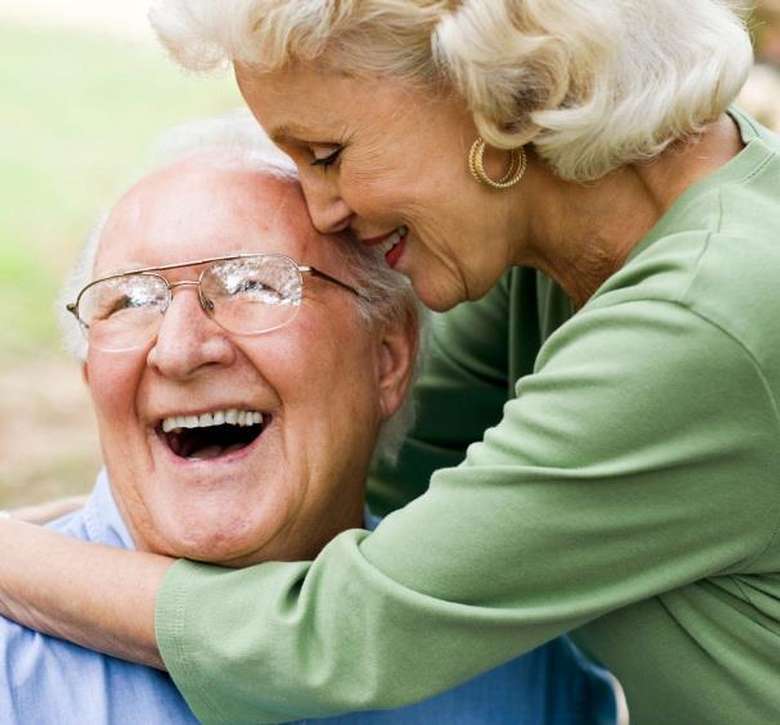 an elderly couple smiling and embracing