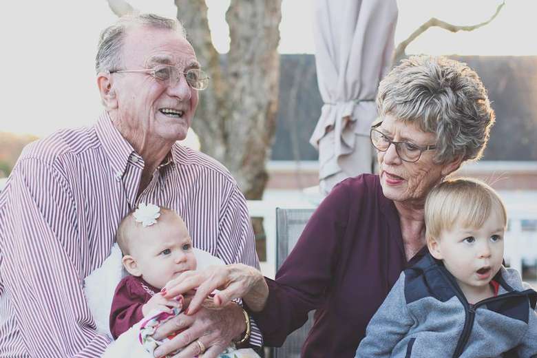 an elderly couple with their grandchildren