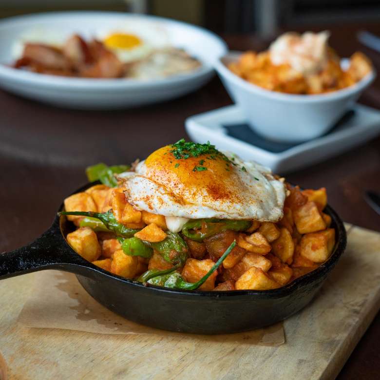 skillet pan with fried potatoes with fried egg on top