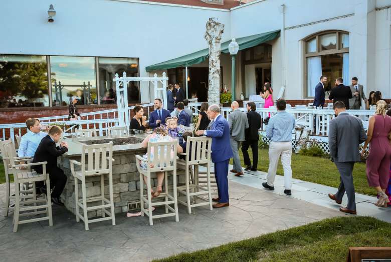 people at a wedding mingling in a patio area