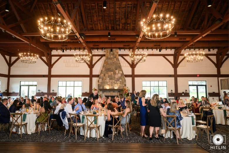 people seated at tables in a wedding reception space