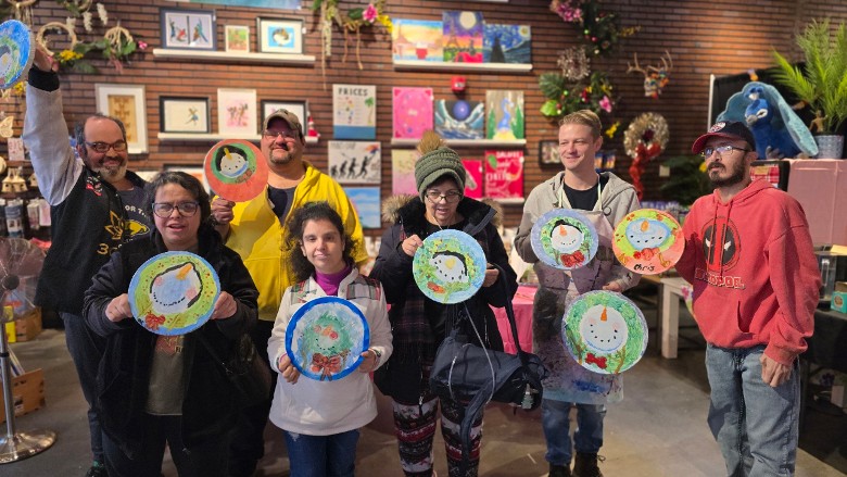 group of people holding up artworks