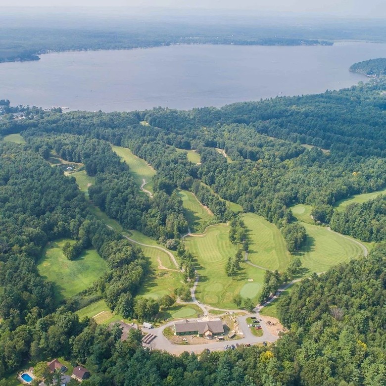 aerial view of a golf course with a lake in the background