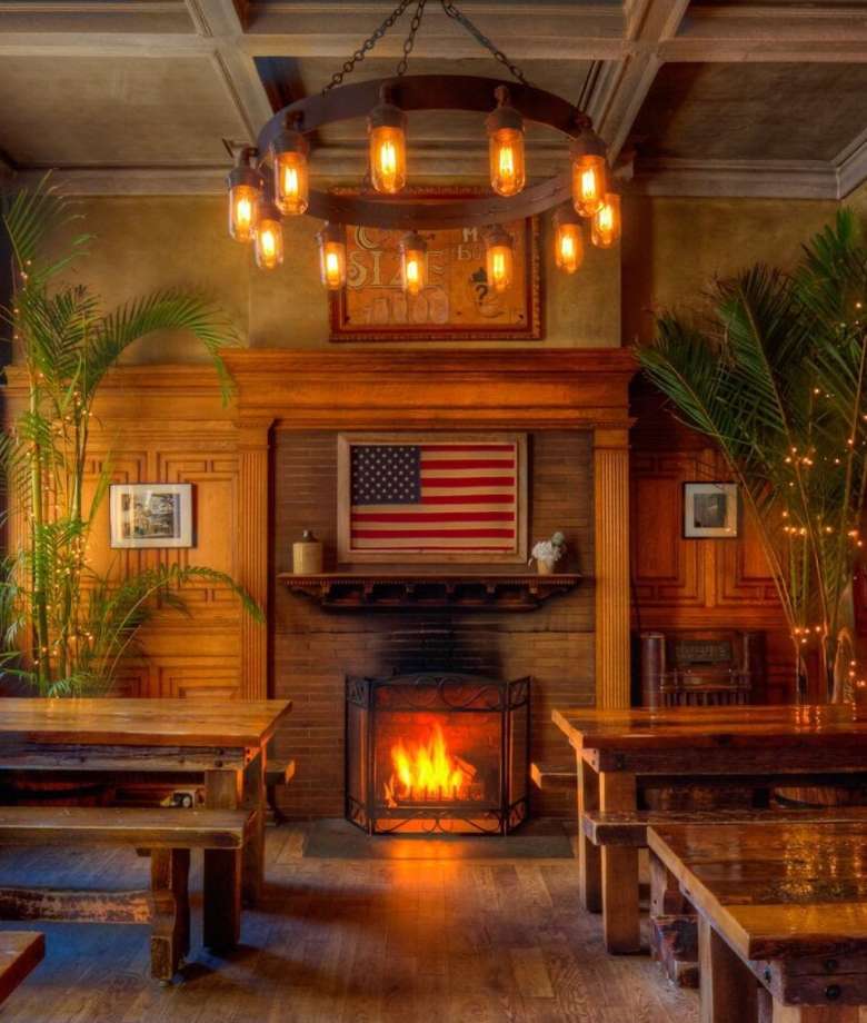 long wooden tables near a fireplace in a dining room