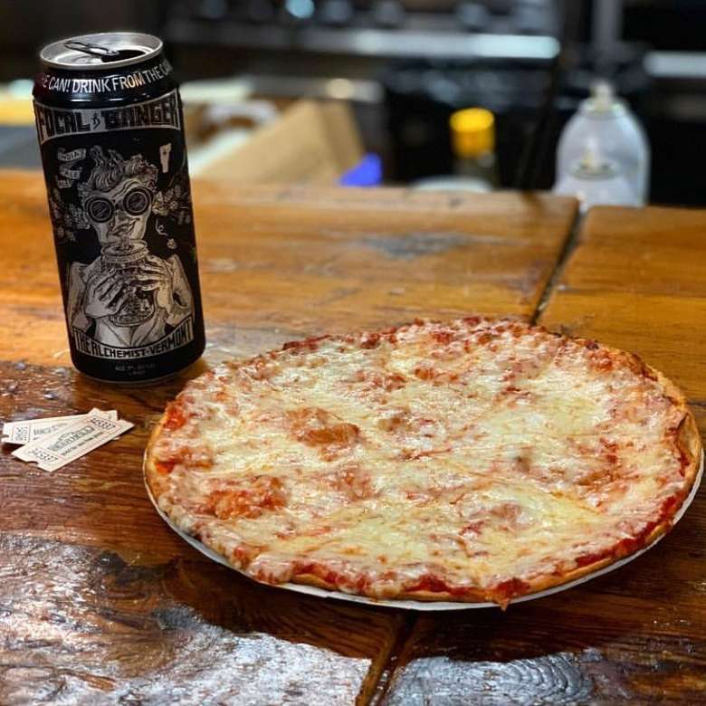 a personal cheese pizza next to a can of beer