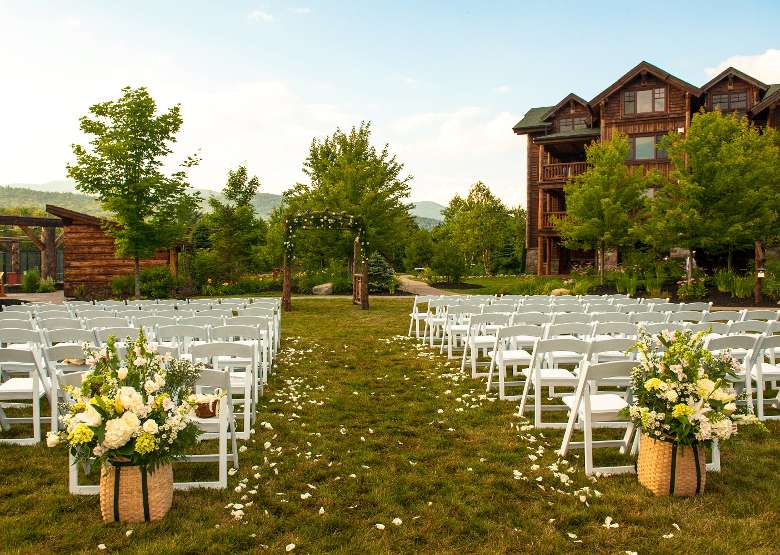 rows of white chairs set up for an outdoor wedding ceremony