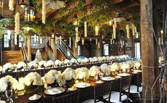 tables decorated for a formal occasion with large floral centerpieces and flowers hanging from the ceiling