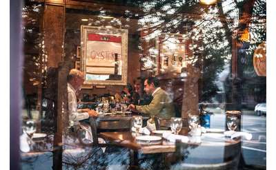 people dining in the brook tavern as seen through the front window