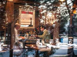 people dining in the brook tavern as seen through the front window