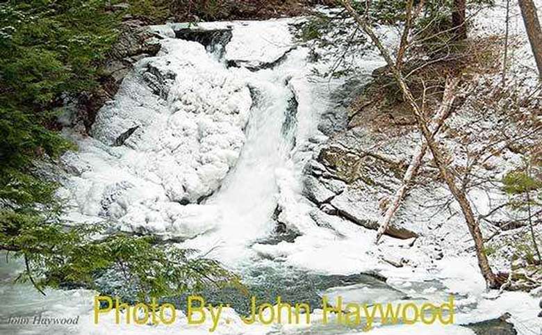 mostly frozen waterfall with photo credit to john haywood