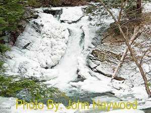 mostly frozen waterfall with photo credit to john haywood