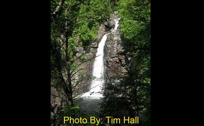 very steep narrow waterfall dropping into a pool with photo credit to tim hall