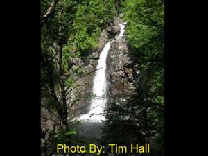 very steep narrow waterfall dropping into a pool with photo credit to tim hall