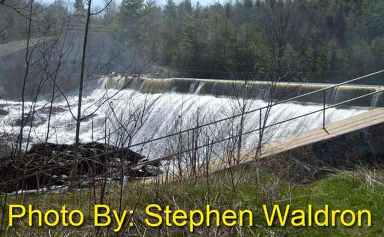 water rushing out of a dam with photo credit to stephen waldron