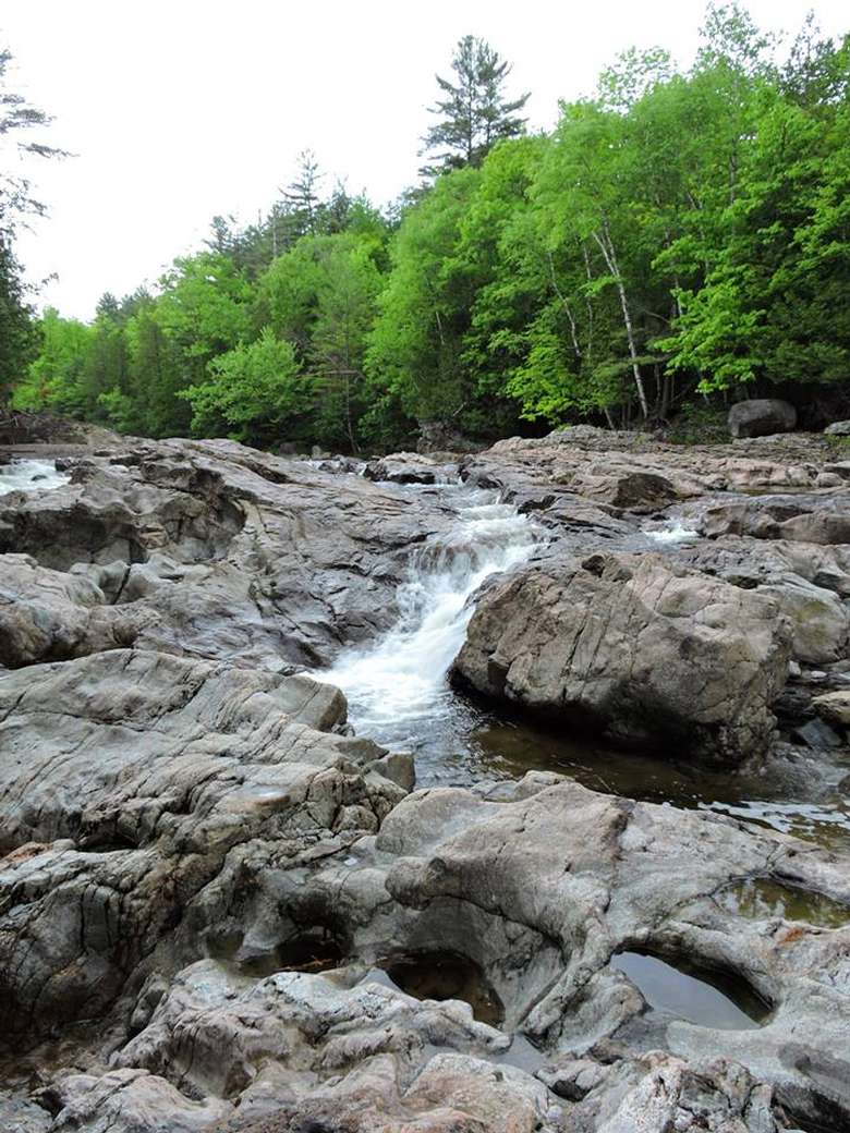 narrow stream of water rushing along rocks