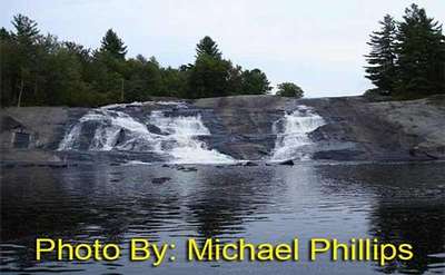 waterfall flowing down a rock face with photo credit to michael phillips