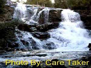 waterfall flowing over rocks with photo credit to care taker
