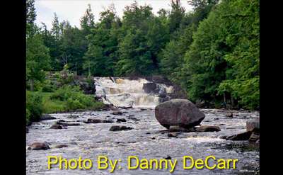 two-tiered waterfall flowing over rocks with photo credit to danny decarr