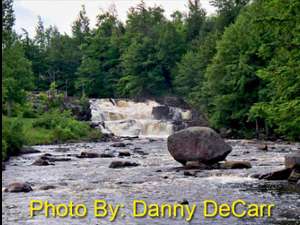 two-tiered waterfall flowing over rocks with photo credit to danny decarr