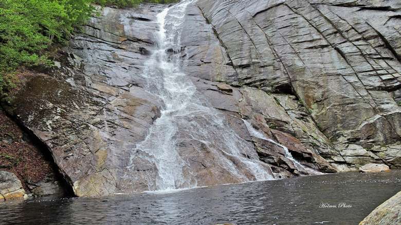 view from below of a steep waterfall dropping down a rock face