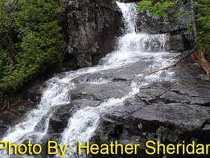 waterfall flowing over rocks with photo credit to heather sheridan
