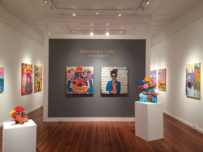 art gallery showing the symphony in color exhibition with sculptures and paintings on the walls