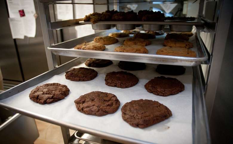 trays full of large cookies and muffins in a rack