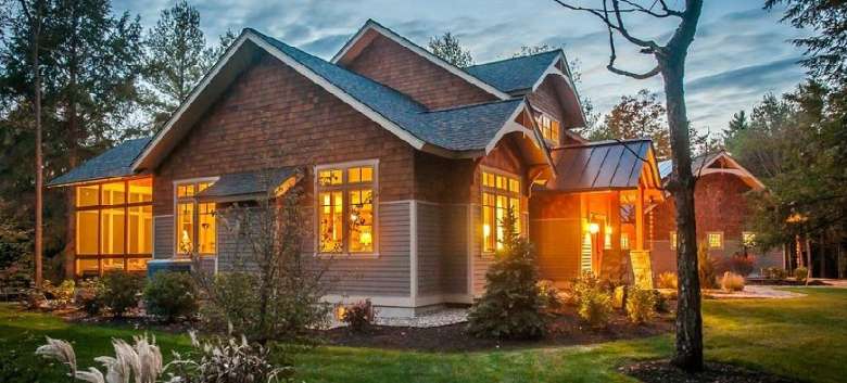 exterior of a home with yellow lights shining from the windows