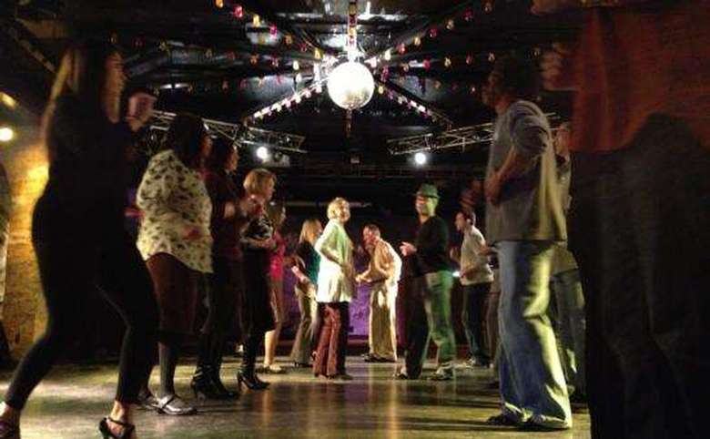 group of people dancing under a disco ball