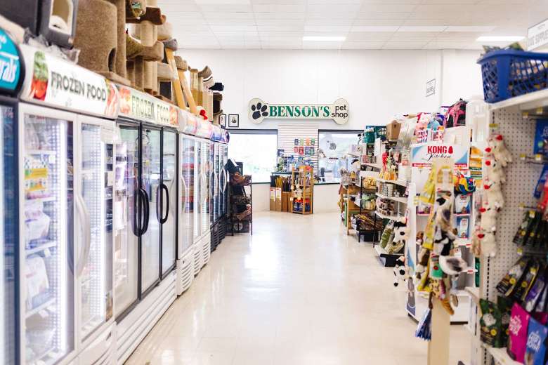 aisle in a pet store with freezers on the left