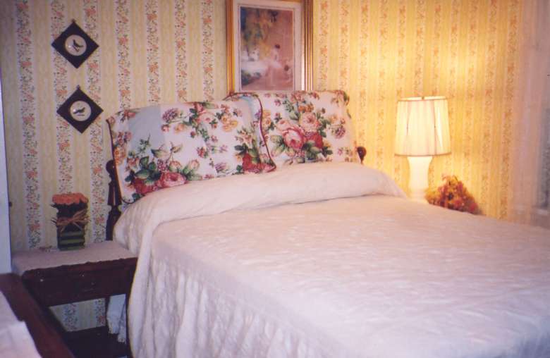 a bedroom with a bright light at one end and a bed with white blankets