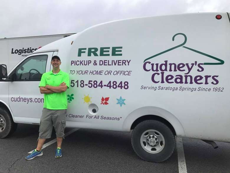 man standing near van with the cudney's cleaners logo and name