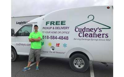 man standing near van with the cudney's cleaners logo and name