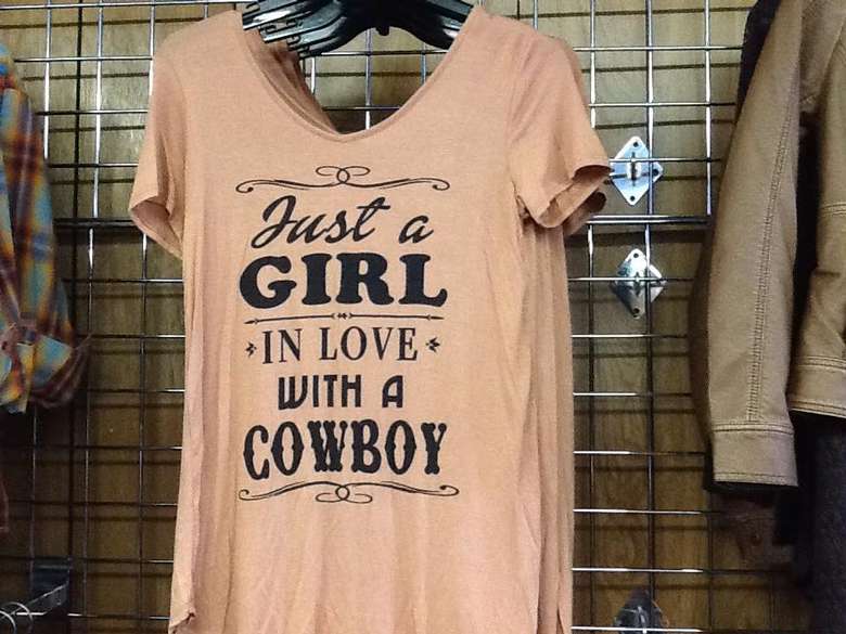 a peach colored top that says "just a girl in love with a cowboy"